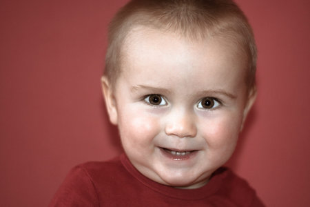 Portrait of cute toddler over red background