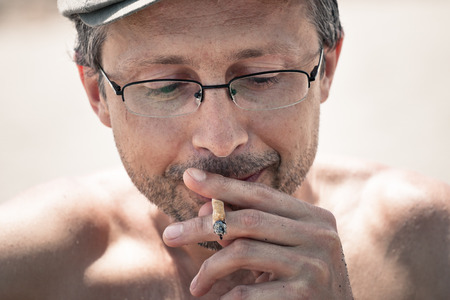 Close up of a man smoking hashish joint.の写真素材