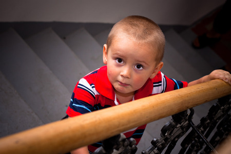 Scared looking boy on stairs.の写真素材
