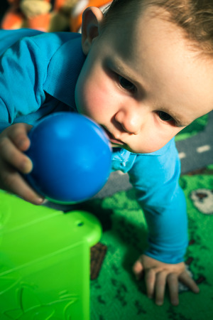 Baby boy playing with ball indoors.の写真素材