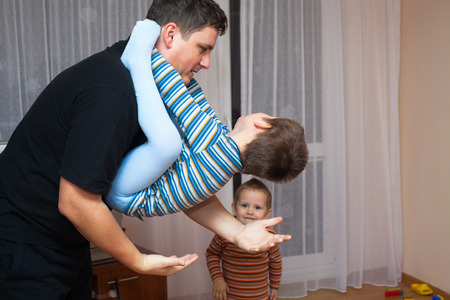 Happy father playing with his child boy at homeの写真素材