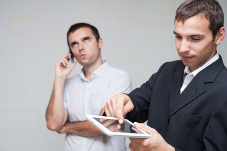 Two businessmen using digital tablet and smartphone.の写真素材