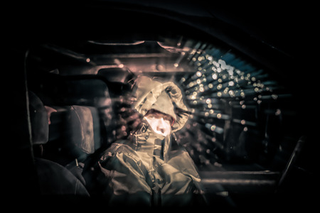 Creative abstract photo of a man through car glass at nightの写真素材