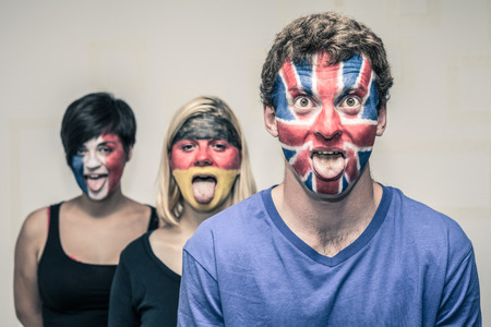 Group of funny people with painted European flags on their faces and sticking out tongue.の写真素材