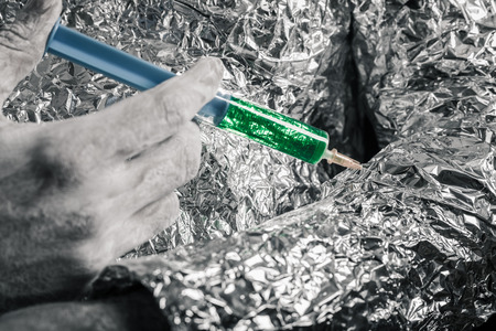 Closeup of cyborg hand applying syringe.の写真素材