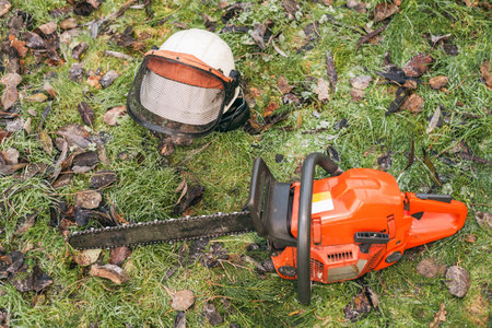 Chainsaw and helmet lying on the ground.