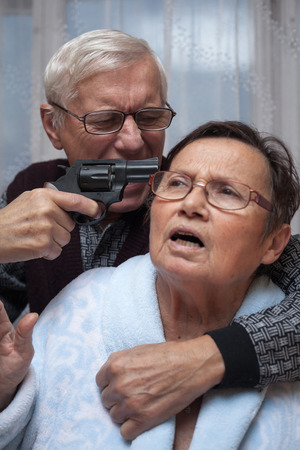 Mad senior couple fighting with a gun.の写真素材