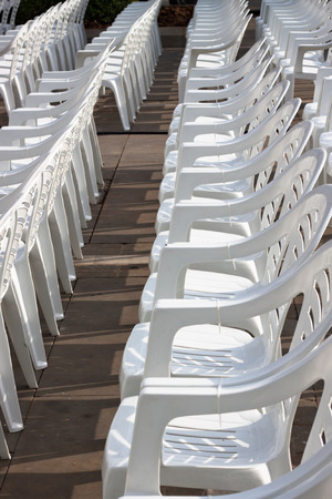 Empty white plastic chairs for an outdoor event.の写真素材