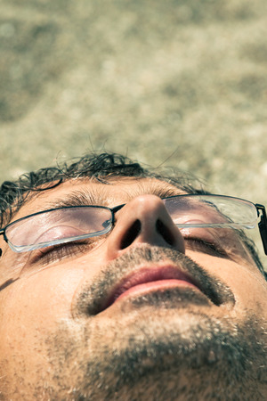 Closeup of middle aged man sleeping on the beach.の写真素材