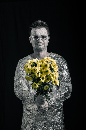 Portrait of happy spaceman holding flowers.の写真素材