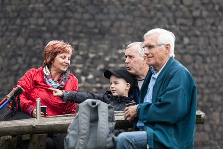 Seniors with child on family hiking trip relaxing outdoors.の写真素材