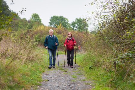 Senior couple Nordic walking on rocky trail in the nature.の写真素材