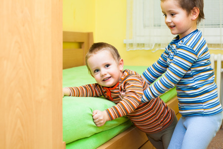 Two children playing together and having fun at homeの写真素材