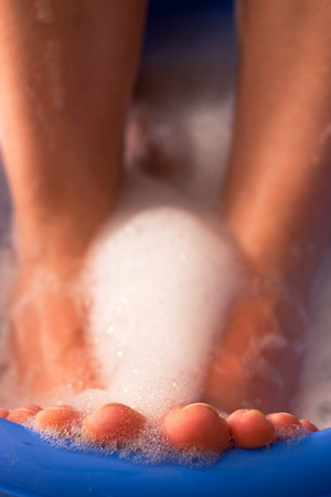 Detail of female feet in soap bath.の写真素材
