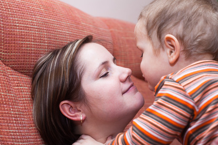 Closeup of happy mother kissing her child boyの写真素材