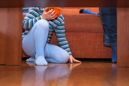 Detail of child with ball sitting on the floor.の写真素材