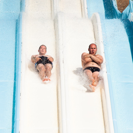 People having fun, sliding at water park.の写真素材