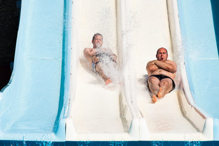 People having fun, sliding at water park.の写真素材