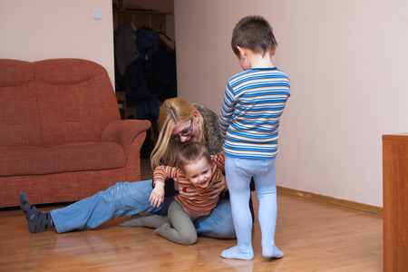 Happy children and woman having fun at homeの写真素材
