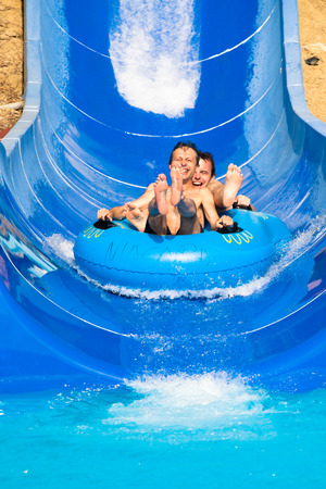 People having fun, water sliding at aqua park.の写真素材