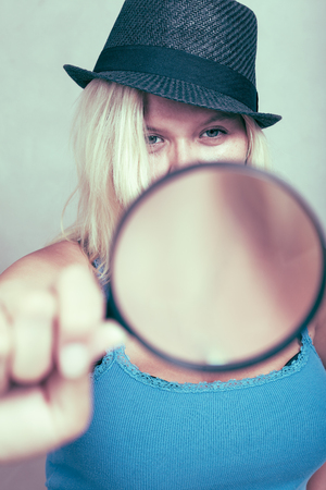 Female detective holding magnifying glass, research and investigation concept.の写真素材
