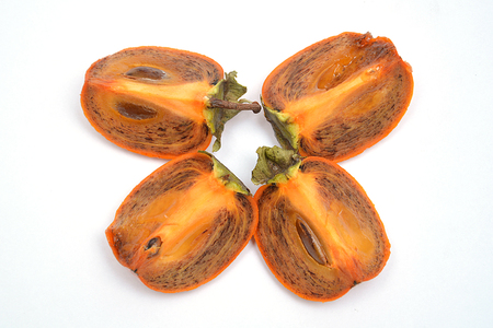 fruit on white background pomegranate grain grenade and persimmonの写真素材