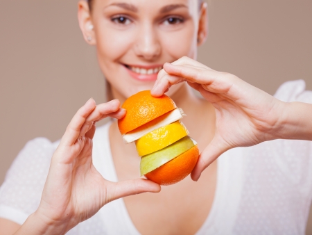 Woman drinking orange juice smiling showing oranges  Young beautiful mixed-race Asian   Caucasian modelの写真素材