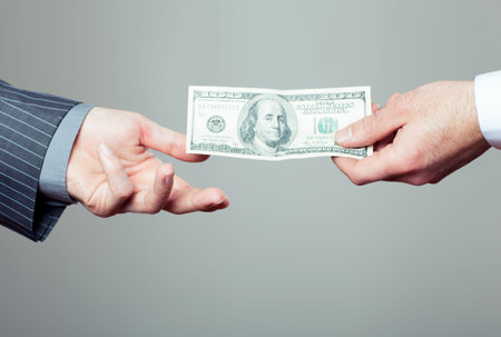 Hand handing over money to another hand 