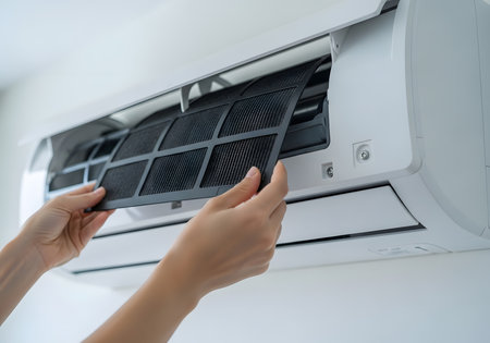 Close up of female hands adjusting air conditioner in air conditionerの素材
