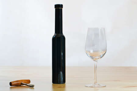 Still life photo of with bottle, wineglass and a corkscrew on the table with white backgroundの写真素材