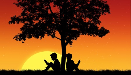Silhouettes of children read book under treeの写真素材