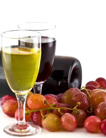 A glass of white wine, red wine and grapes on white background.の写真素材