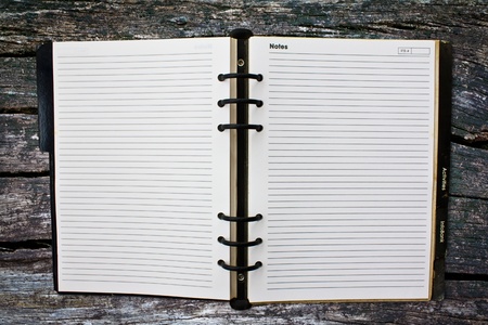 Old notebook (blank paper) on wood wall.の写真素材