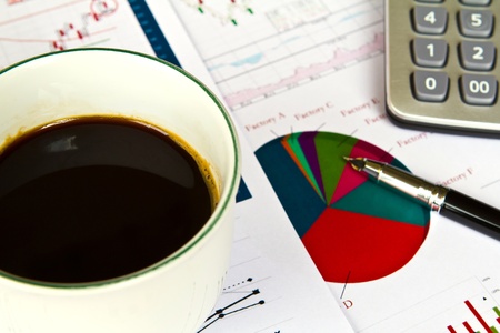 Various financial charts on the table with calculator, coffee and penの写真素材