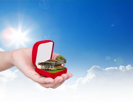House in ring box on hand against the blue skyの写真素材