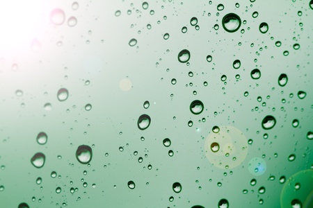 Background of water drops on a window glass in a rainy dayの写真素材