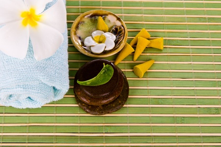 Frangipani flowers and leaves with zen stones on a bamboo matの写真素材