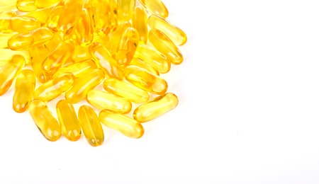 Capsules of fish oil and vitamins on white background.の写真素材