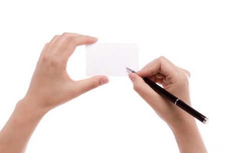 Female hand with pen writing on blank cardの写真素材