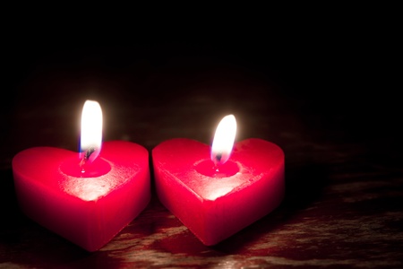 Red burning heart shaped candlesの写真素材