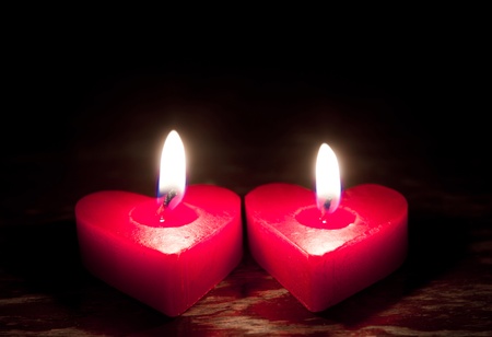 Red burning heart shaped candlesの写真素材
