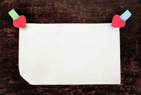 close up of an old paper and clothes peg on a wooden background
