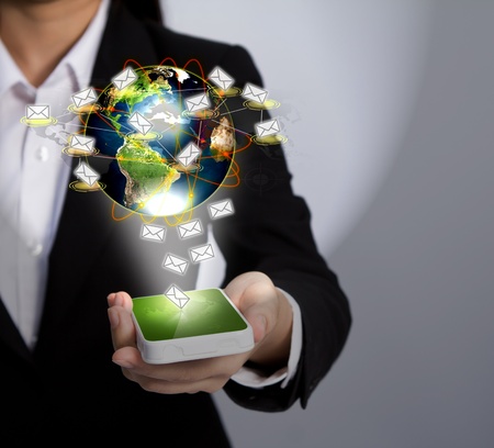 Hand holding a phone show Earth and mailの写真素材