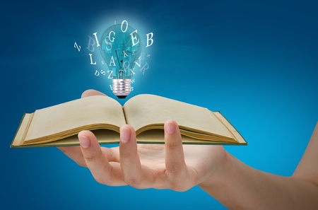 Book and light bulb on handの写真素材