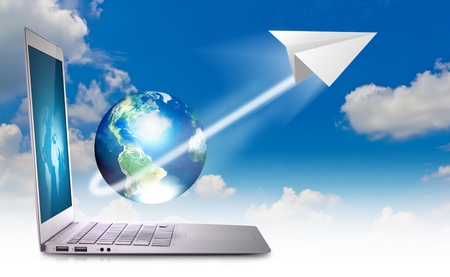 laptop in sky with earth and paper planeの写真素材