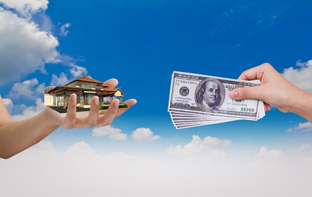 Hand exchange House with Dollar over blue skyの写真素材