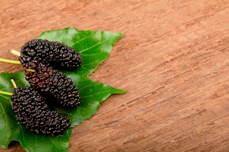 Mulberry and leaf on old woodの写真素材