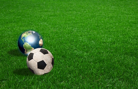 soccer ball and earth on green grass (Elements of this image furnished by NASA)の写真素材