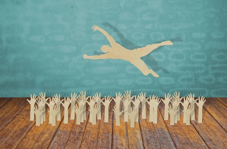 Paper cut of man jump over jubilant crowdの写真素材