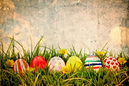 Grunge paper with Easter Eggs and flower on Fresh Green Grass over blue skyの写真素材